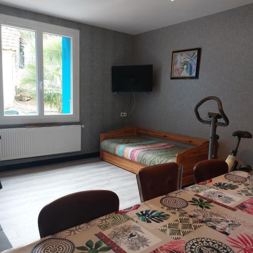 une chambre avec deux lits et une télévision au mur dans l'établissement floryll, à Fumel