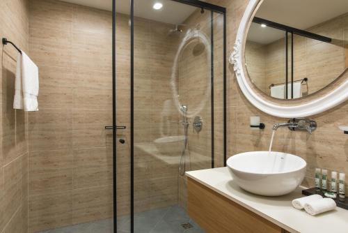a bathroom with a sink and a shower with a mirror at Wine & SPA Hotel Chukara in Tryavna