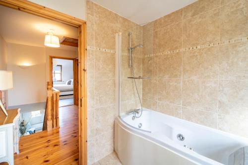 a bathroom with a tub and a shower and a tub at Dingle View - 37 Tír Na Fiuise in Dingle