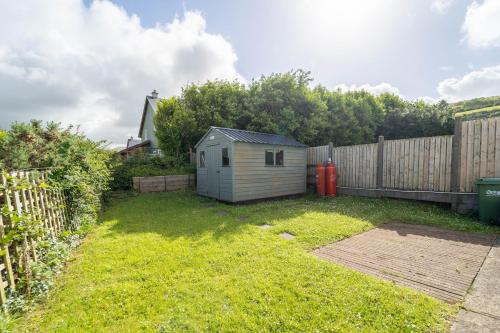 a backyard with a small shed next to a fence at Dingle View - 37 Tír Na Fiuise in Dingle