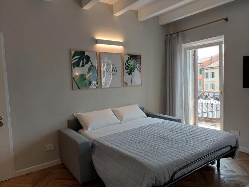 um quarto com uma cama e uma grande janela em HomeThirtyFour em Verona