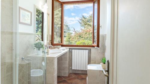 baño con lavabo y ventana en Casa Maravilla 6, Emma Villas, en Castelnuovo Berardenga