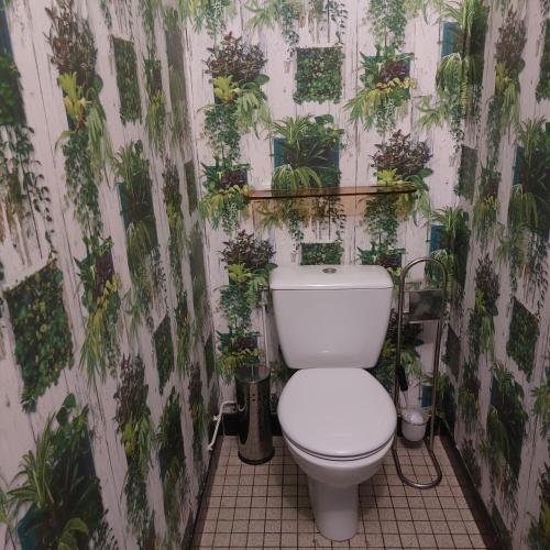 La salle de bains est pourvue de toilettes avec des plantes sur le mur. dans l'établissement floryll, à Fumel