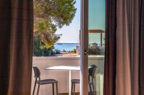 a view of the ocean from a balcony with a table and chairs at NOHA Lifestyle Hotel - Adults Only in Pula