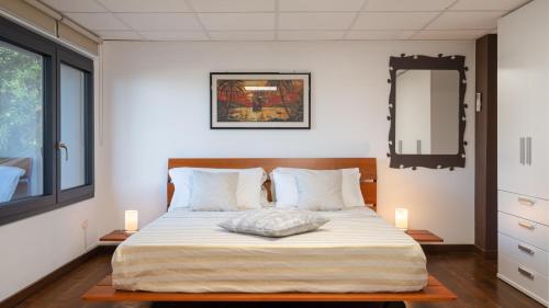 Schlafzimmer mit einem Bett mit einem Spiegel und einem Fenster in der Unterkunft Villa Night and Day 62 Emma Villas in Alcamo