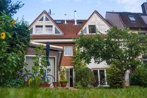 a large brick house with a tree in the yard at Ferienwohnungen am Schwanensee in Plön