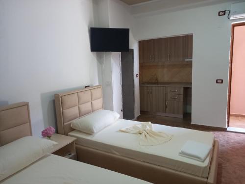a small bedroom with two beds and a kitchen at Bar Restorant Hotel Altini in Vlorë