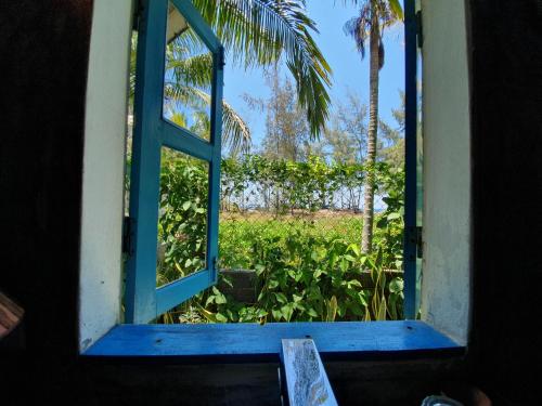 an open window looking out at a garden at An Bang Hideaway in Hoi An