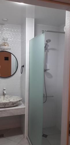 een badkamer met een douche, een wastafel en een spiegel bij sharing apartment kutaisi in Koetaisi