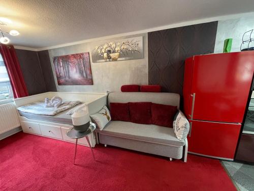 een kamer met een bank en een rode koelkast bij Tiny House in Burig