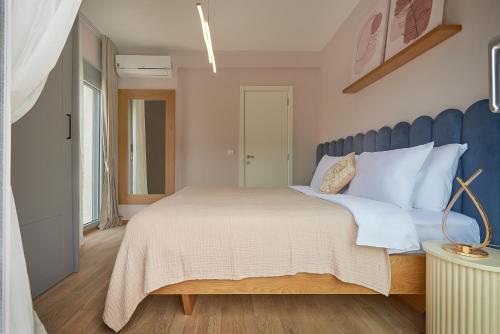 a bedroom with a large bed with a blue headboard at 2MONTENEGRO LIMETA APARTMENTS with pool in Kotor