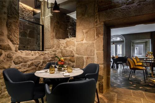 a dining room with stone walls and a table and chairs at Pousada Porto Rua das Flores in Porto