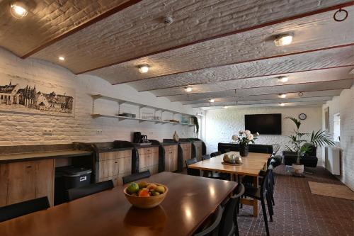 a kitchen with a table with a bowl of fruit on it at Hoeve Ten Rooden Duifhuize in Sint-Denijs