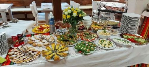 a table with plates of food on a table at Pensjonat Willa w Parku in Polanica-Zdrój