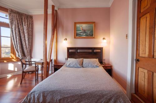 a bedroom with a bed and a table and a chair at Casa Vander Hotel Boutique in Valparaíso