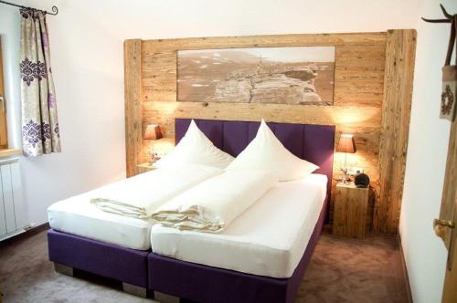 ein Schlafzimmer mit einem großen Bett mit weißen Kissen in der Unterkunft Apart Schmid in See