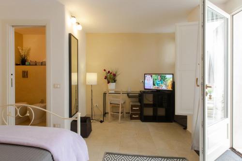 a bedroom with a bed and a desk and a television at Bella Vista b&b in Erice