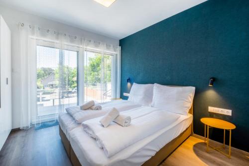 a large white bed in a room with a large window at MyFlat Villa Nuvola in Siófok