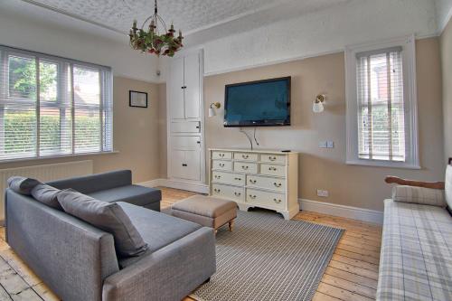 a living room with a couch and a tv at Victorian Villa close to Liverpool City Centre in Liverpool