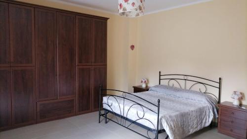 a bedroom with a bed and wooden cabinets at Casa panoramica tra mare e montagna alle pendici della Sila in Bianchi