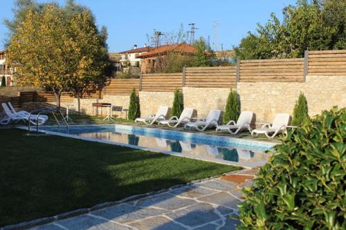 a row of lounge chairs next to a swimming pool at Family Hotel Friends Villa in Enchets