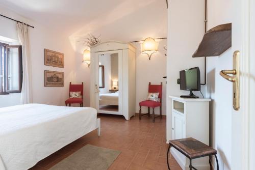 Habitación de hotel con cama y TV en Locanda La Luna, en Tirli