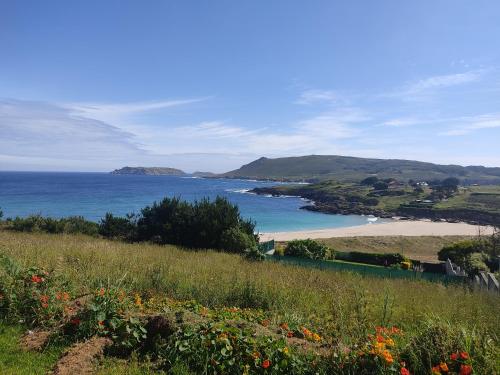 a view of a beach and the ocean at Casa completa - Camiño dos faros - Atlantico Malpica in Malpica