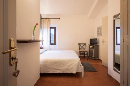 a bedroom with a bed with a vase with a flower in it at Locanda La Luna in Tirli