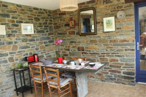 a table in a room with a stone wall at ROC callac in Saint-Gilles-du-Vieux-Marché