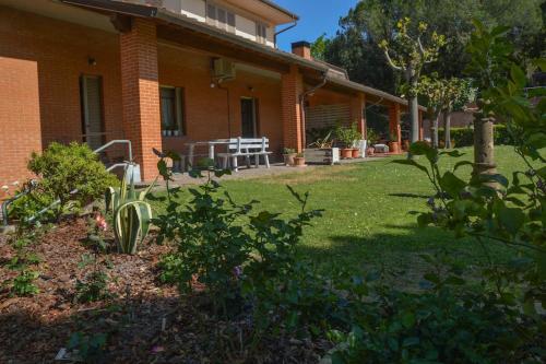 ein Backsteinhaus mit einem Hof mit einem Tisch und Stühlen in der Unterkunft Casa vacanze Gemma Toscana in Capannoli