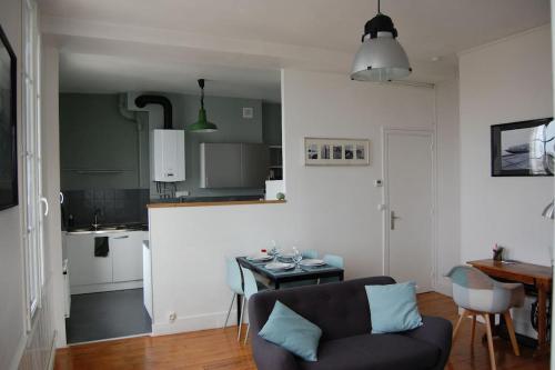 a living room with a couch and a table in a kitchen at "L'amarrage" 2 chambres Perret Pleine Vue Mer in Le Havre