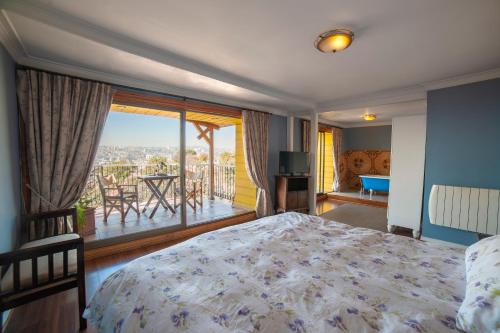 a bedroom with a bed and a balcony with a view at Hotel Boutique Casa Vander in Valparaíso