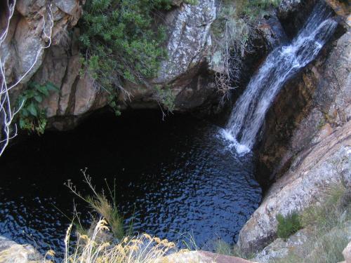 a waterfall on the side of a rocky cliff at Joel's Off Grid Cottage in the Klein Karoo in Oudtshoorn