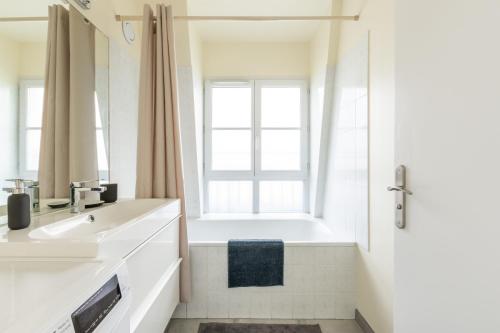 une salle de bain avec une baignoire, un lavabo et une fenêtre dans l'établissement Sweet Family Vacations - Fairytale Factory, à Chessy