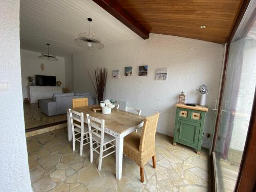 une salle à manger avec une table, des chaises et un canapé dans l'établissement Le petit courrier, à Mimizan