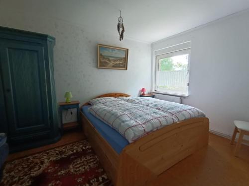 een slaapkamer met een bed en een raam bij Old German Farm House, Appartement in Aurich