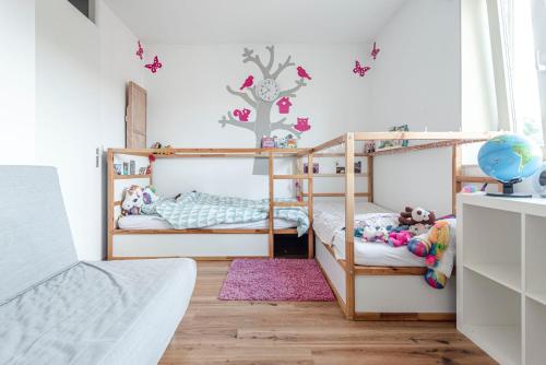 a bedroom with two bunk beds and a pink rug at FamilyHome near the Ocean in Scheveningen