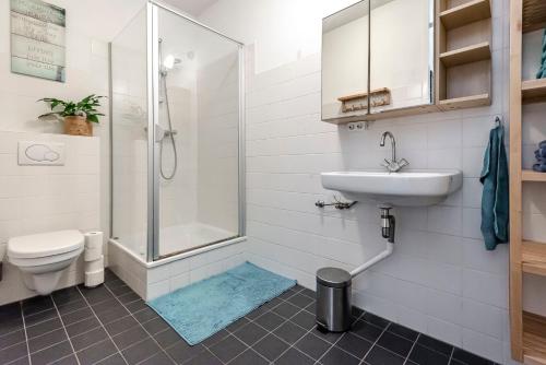 a bathroom with a shower and a sink and a toilet at FamilyHome near the Ocean in Scheveningen