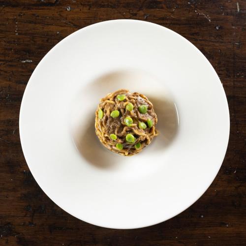 a doughnut on a white plate on a table at Locanda La Luna in Tirli