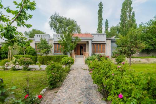 a house with a garden in front of it at Skardu Orchard Guest House in Skardu