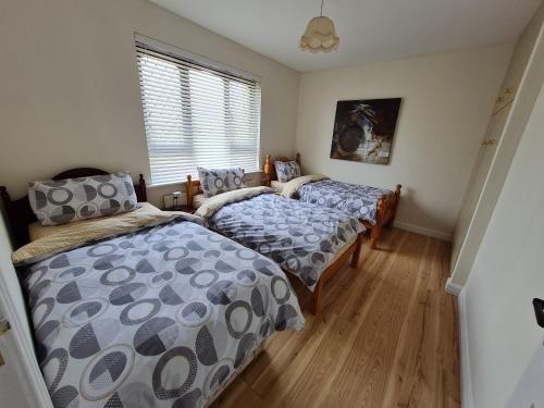 1 dormitorio con 2 camas y ventana en Farnaught Farmhouse Apartment, Lough Rynn, Mohill en Farnaght