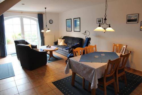 sala de estar con mesa y sofá en Deichgraf, en Greetsiel