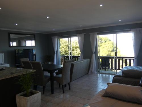 a living room with a table and chairs and a balcony at Knysna Lagoon View in Knysna