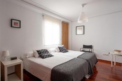 Un dormitorio con una cama grande y una ventana en Calle San Jacinto, 57 Apartamento, en Sevilla