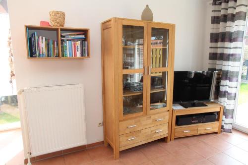 a wooden entertainment center with a tv and a book shelf at Anika in Norddeich