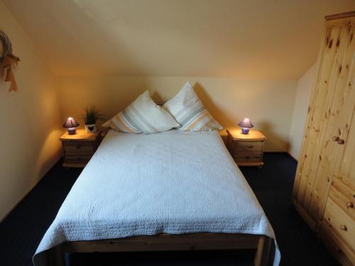 a bedroom with a large bed with two night stands at Friesenstern in Norden