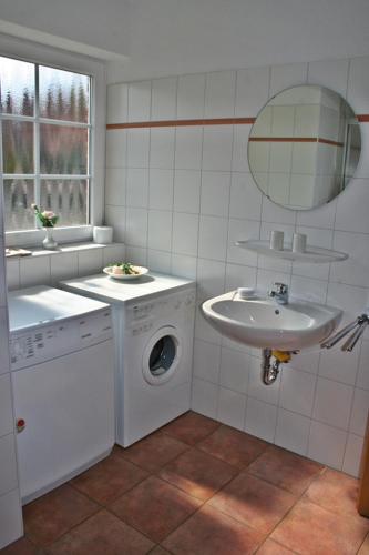 a bathroom with a washing machine and a sink at Friesenstern in Norden