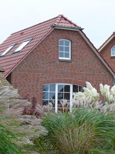 a red brick house with a window and some plants at See in Sicht in Sternberg