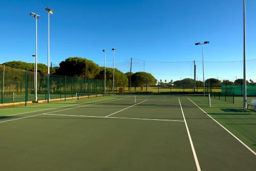 a tennis court with two tennis courts at Iberostar Waves Royal Andalus in Chiclana de la Frontera