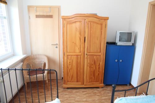 a room with a wooden cabinet and a television at Villa Petra in Norddeich